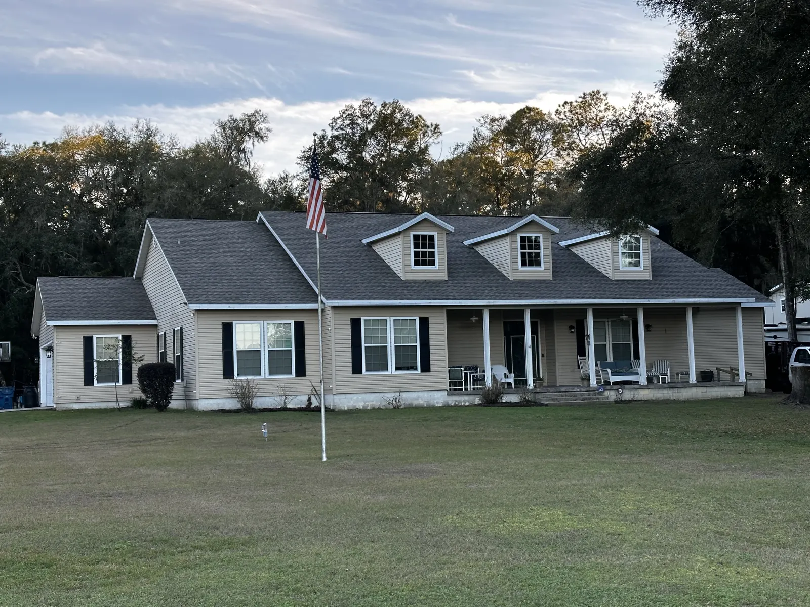 Cape Cod house with a new shingle roof and flag on a residential street in Plainfield, IL