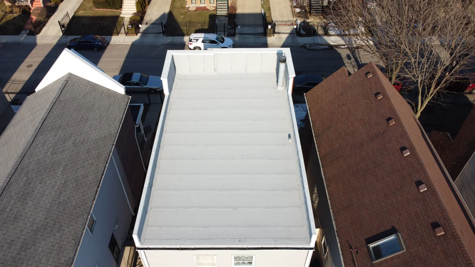 White coated garage flat roof from above in a Chicago neighborhood