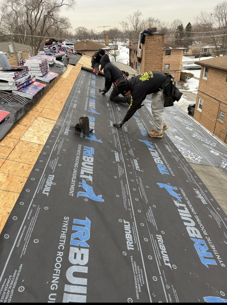 Winter underlayment installation on a steep roof deck near Chicago