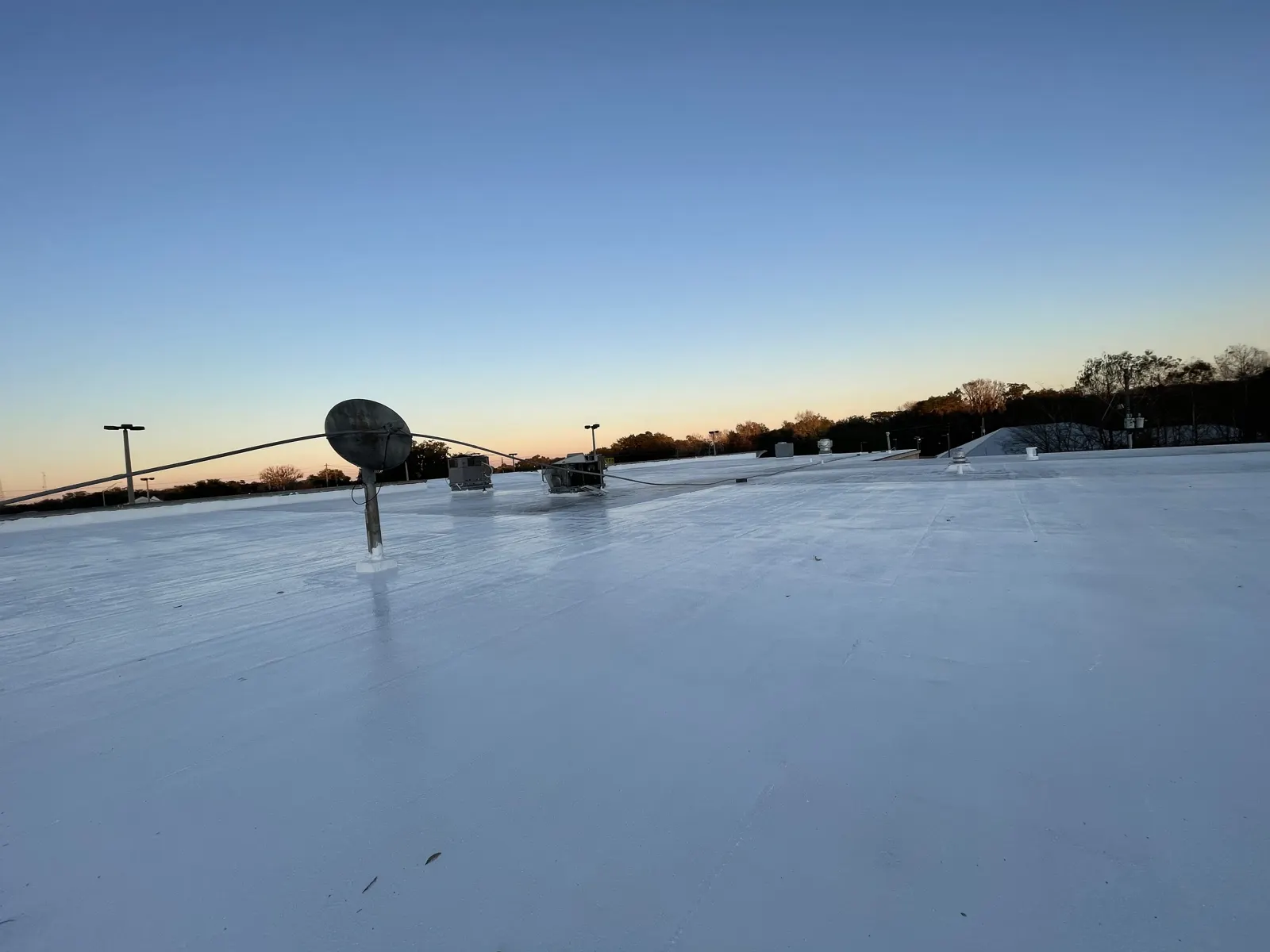 White membrane flat roof photographed at dusk after repair work in Chicagoland